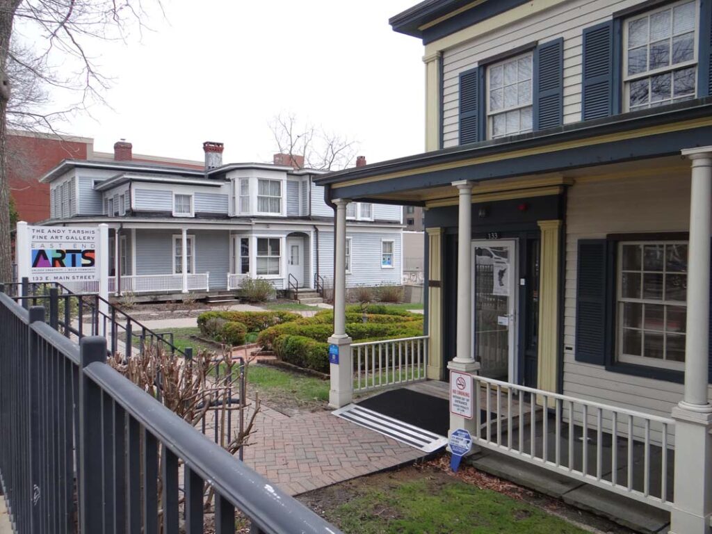 Two historic houses, one in the background and half of one in the foreground.