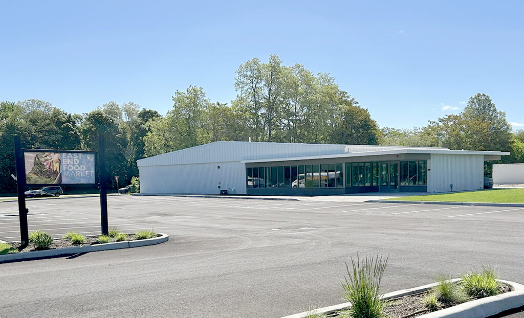 A blue sky day and a white building in the background with a freshly paved parking lot in the foreground